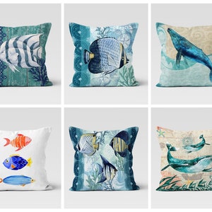Può includere: Sei diversi design di cuscini con una varietà di vita marina, tra cui pesci, balene e coralli. I cuscini sono tutti rettangolari e hanno uno sfondo bianco con accenti blu e verdi.