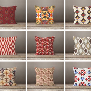 May include: Nine different throw pillow designs with geometric patterns in red, white, blue, yellow, and brown. The pillows are arranged in three rows of three.
