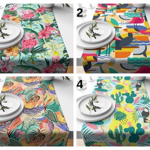 Peut inclure: Quatre designs différents de chemins de table avec des motifs tropicaux. Le premier chemin de table a un fond bleu clair avec des flamants roses, des feuilles vertes et des fleurs tropicales. Le deuxième chemin de table a un fond jaune avec des toucans colorés, des feuilles vertes et des vagues bleues. Le troisième chemin de table a un fond jaune avec des feuilles orange, roses et vertes, et une variété de formes abstraites. Le quatrième chemin de table a un fond jaune avec des flamants roses, des cactus verts et des feuilles vertes.