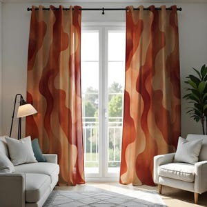 Puede incluir: Un par de cortinas de color naranja y marrón con un diseño ondulado cuelgan frente a una ventana. Las cortinas están hechas de una tela suave y fluida y tienen un brillo sutil.