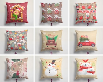 Könnte beinhalten: Neun verschiedene Weihnachtskissenbezüge mit verschiedenen Designs. Die Designs beinhalten ein Rentier in einem Fenster, Lebkuchenhäuser, Weihnachtsmann, Kekse, einen roten LKW mit einem Weihnachtsbaum, einen Schneemann und einen Eisbären.