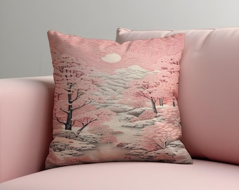Op de afbeelding: Een decoratief kussen met een Japanse landschapsscène. Het ontwerp toont een rivier, kersenbloesem bomen en een bergketen in roze, wit en grijs. Het kussen heeft een textuur en een zacht uiterlijk.
