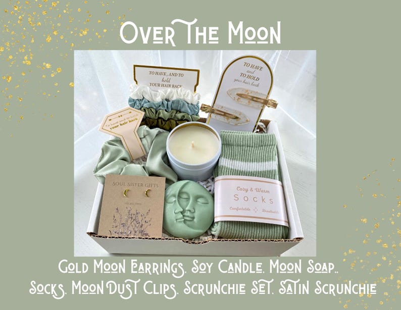 May include: A gift box with the text "Over The Moon" contains gold moon earrings, a soy candle, moon soap, socks, moon dust clips, a scrunchie set, and a satin scrunchie. The box includes hair accessories and a candle.