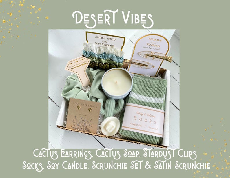 May include: A gift box with the text "Desert Vibes" contains a variety of items. These include a scrunchie set, socks, a soy candle, cactus earrings, cactus soap, and hair clips. The box is decorated with a desert theme.