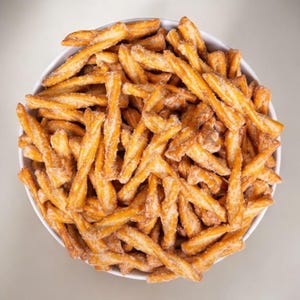 May include: A white bowl filled with golden brown pretzel twists covered in a light dusting of sugar.