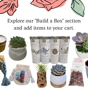 May include: A collection of items for a self-care gift box, including a candle, tea, bath salts, crystals, and succulents. The text "Explore our "Build a Box" section and add items to your cart." is displayed at the top of the image.