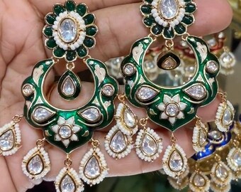 May include: A pair of green and white enamel earrings with intricate floral designs and clear stones. The earrings have a dangling design with multiple teardrop-shaped stones.