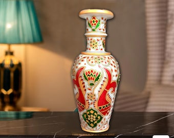 Könnte beinhalten: Weiße Marmorvase mit aufwendigen roten, grünen und goldenen Blumendesigns. Die Vase hat eine breite Öffnung und einen schmalen Hals.