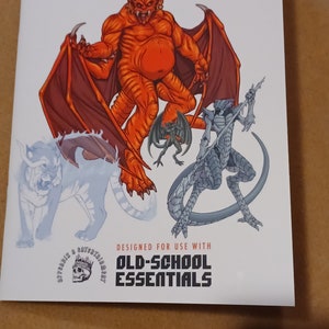 May include: A white booklet with the title "Gateway to Adventure: Devilry" and a colorful illustration of a red devil, a grey dragon, and a white wolf. The booklet is designed for use with "Old-School Essentials".