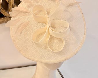 Ivory hatinator with flower and feathers (Lilia-Jane). Available in other colours. Feathers underneath mirror feathers on top.