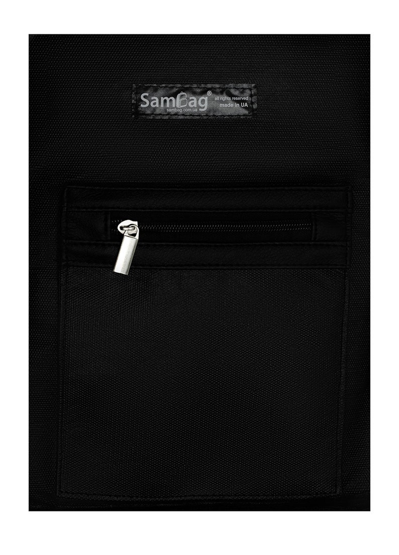 May include: Black bag with a zippered pocket and a silver zipper pull. The bag has a textured surface and a small label with the text "SamBag" and "made in UA".