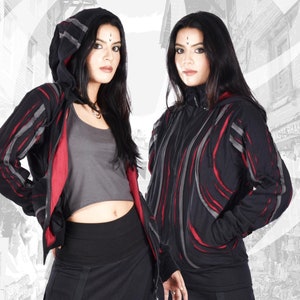 Może przedstawiać: Dwie kobiety w czarno-czerwonych, paskowanych kurtkach z kapturem zapinanych na zamek błyskawiczny. Kurtki mają unikalny wzór z czerwonymi i szarymi paskami. Kobiety mają na sobie czarne spodnie i długie czarne włosy.