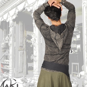 Op de afbeelding: Een grijs hooded longsleeve shirt met een zwarte riem en een groene rok. Het shirt heeft een distressed look met rafelige randen en een losse pasvorm.