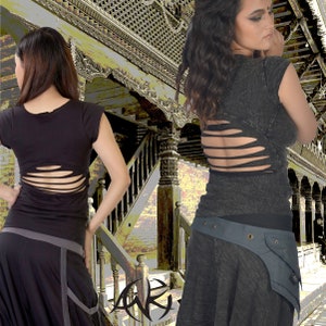 Könnte beinhalten: Zwei Frauen tragen schwarze Shirts mit Ausschnitten im Rücken. Die Shirts sind aus einem weichen, strukturierten Stoff. Die Frauen stehen vor einem Holzgebäude mit einer Treppe.