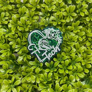 Puede incluir: Pegatina en forma de corazón verde con purpurina, contorno blanco y el texto "Hi Tech" en su interior. La pegatina tiene un diseño floral en la parte superior.