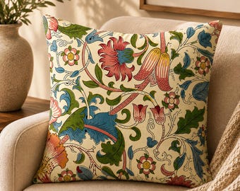 May include: A square throw pillow featuring a cream-colored background with a dense, intricate botanical pattern. The design includes stylized flowers and leaves in shades of pink, coral, blue, and green, connected by winding, thin brown stems.