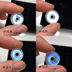 May include: Four iridescent moonstone donut beads with a hole in the centre. The beads are different sizes, ranging from 13.6 mm to 17.7 mm. Each bead is labelled with a number and its diameter in millimetres.