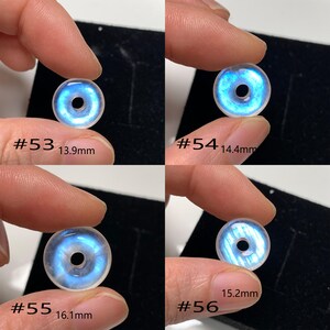 May include: Four iridescent moonstone beads with a hole in the centre. The beads are different sizes, ranging from 13.9 mm to 16.1 mm. Each bead is labelled with a number and its diameter in millimetres.
