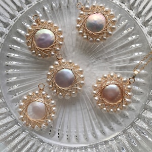 May include: Five gold wire wrapped pendants with white pearls. Each pendant features a circular pearl surrounded by a wire design and a ring of pearls.