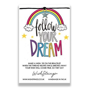 May include: A white card with a rainbow, clouds, and stars, featuring the words "follow YOUR DREAM" in colorful letters. A silver star charm hangs from a black string. The card includes text about making a wish.