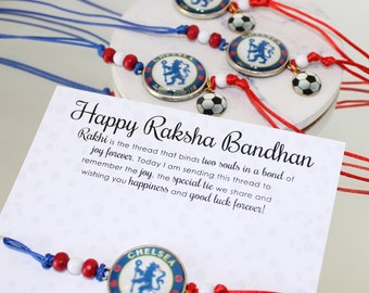 May include: A set of Rakhi bracelets featuring the Chelsea Football Club logo in a circular metal frame, accented with red and white beads and a small soccer ball charm. The bracelets are displayed on a card with the text Happy Raksha Bandhan.