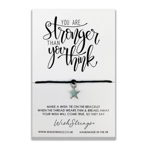 May include: Black string bracelet with a silver star charm. The card reads "You are stronger than you think. Make a wish, tie on the bracelet when the thread wears thin & breaks away your wish will come true, so they say. Wish Strings. www.wishstrings.co.uk Handmade in the UK."