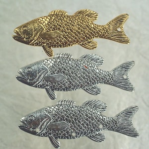 May include: Three metal fish-shaped charms arranged vertically. The top charm is gold-toned, while the middle and bottom charms are silver-toned. Each fish features detailed scale textures, fins, and a small circular hole near the tail or body.