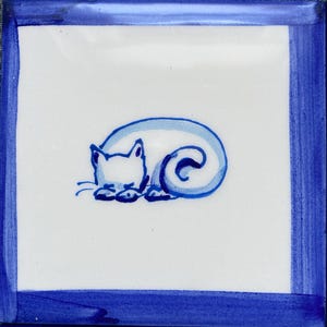 Può includere: Piastrella quadrata in ceramica con centro bianco e bordo blu. La piastrella presenta un'illustrazione stravagante di un gatto che dorme in tonalità di blu. Il gatto è rannicchiato, con la coda che forma una spirale.