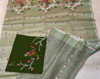May include: A green and white silk saree with a floral design. The saree has a matching blouse piece with a bird design.