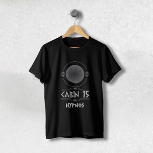 Peut inclure: T-shirt noir avec un motif graphique blanc représentant une spirale, des formes géométriques et le texte "CABIN 15 HYPNOS".