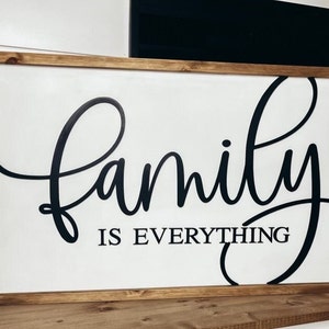 Puede incluir: Un letrero de madera con fondo blanco y letras negras que dice "family is everything".