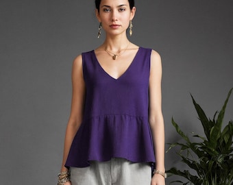 May include: A sleeveless deep purple peplum top with a V-neckline paired with light gray straight-leg trousers and black thong sandals. The outfit is accessorized with gold drop earrings, a gold pendant necklace, and stacked gold bracelets.