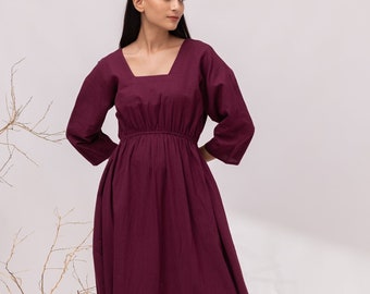 May include: A long, burgundy maxi dress with a square neckline and 3/4 sleeves. The dress has a cinched waist and a flowing skirt.