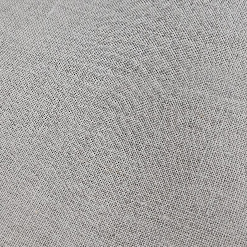 May include: Close-up of a light gray woven fabric with a subtle texture.