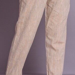 Op de afbeelding: Beige linnen broek met een subtiel gestreept patroon. De broek heeft een gezoomde zoom en een ontspannen pasvorm.