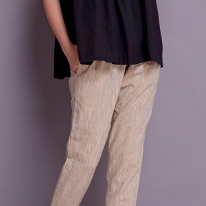Op de afbeelding: Beige linnen broek met een gezoomde zoom. De broek heeft een rechte pijp en een ontspannen pasvorm.