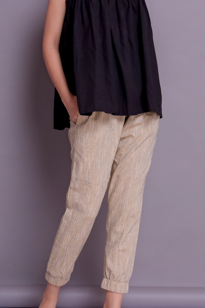 Op de afbeelding: Beige linnen broek met een gezoomde zoom. De broek heeft een rechte pijp en een ontspannen pasvorm.