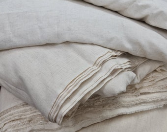 May include: A stack of off-white fabric folded in layers. The fabric has a slightly rough texture and is made of natural fibers.