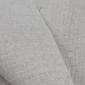 May include: Close-up of a light gray linen fabric with a woven texture.