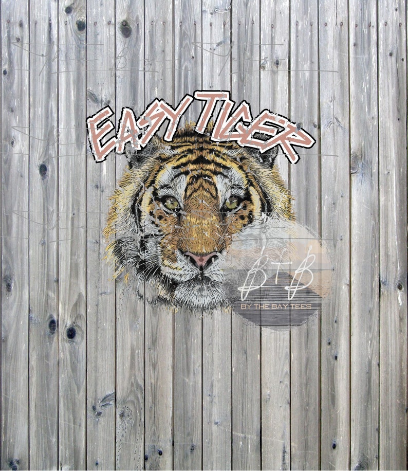 Peut inclure: Illustration num&eacute;rique d'un visage de tigre avec le texte "EASY TIGER" au-dessus. Le tigre a des rayures orange et noires, avec un nez rose et des yeux verts. Le fond est une cl&ocirc;ture en bois vieilli.