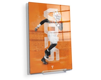 Op de afbeelding: Oranje en witte grafische print van een American footballspeler die rent met het woord "VOLS" in witte letters op een oranje achtergrond.