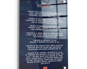 May include: A blue and white glass plaque with the text "The Auburn Creed BELXXVE 1943-2018" and a list of beliefs. The plaque features the Auburn University logo with the letters "AU" in orange and a tiger paw print in white.