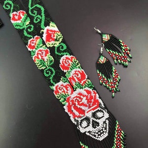 May include: A black beaded necklace with a skull and red roses, and matching beaded earrings with black tassels.