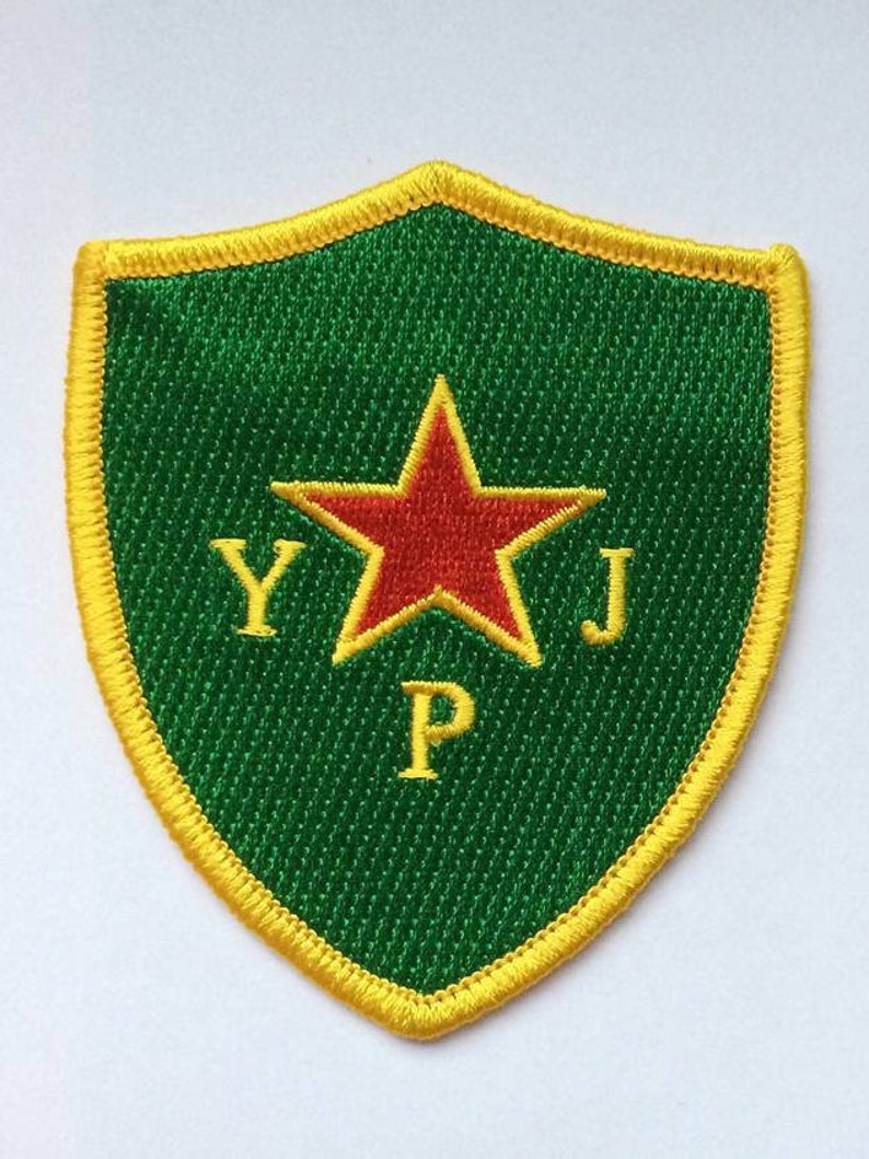 May include: A green and yellow embroidered patch with a red star and the letters "YJP" in the center.