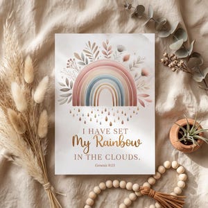 Może przedstawiać: Akwarelowy nadruk z pastelową tęczą z kwiatowymi akcentami i tekstem "I HAVE SET MY RAINBOW IN THE CLOUDS. Genesis 9:13." Grafika ma miękką paletę kolorów i jest otoczona elementami dekoracyjnymi.