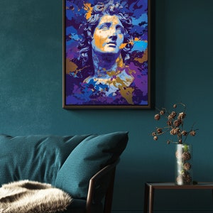 May include: A framed art print featuring a stylized bust of a classical figure. The artwork uses a vibrant color palette of blues, purples, and gold, creating a modern pop art aesthetic. The print is displayed on a teal wall.