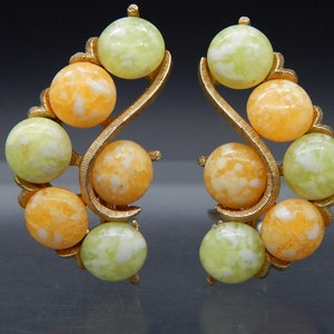 May include: A pair of gold tone clip-on earrings with a swirl design and orange and green marbled beads.