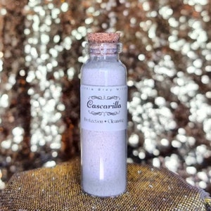 Puede incluir: Una pequeña botella de vidrio con un tapón de corcho llena de polvo blanco. La etiqueta dice "Cascarilla Protection Cleansing".