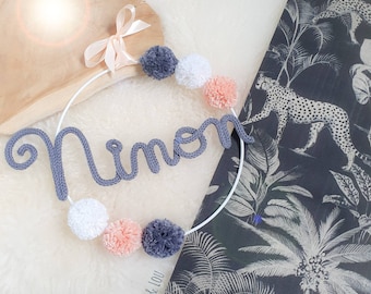 Knitted name wreath with pom-poms, baby room wall decoration