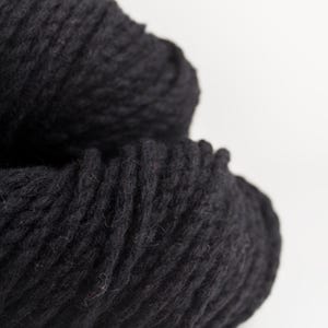 May include: A white ceramic mug with a black handle and the text "But First, Coffee" in a black, bold font. The mug is sitting on a white surface.